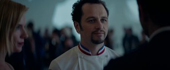 Movie still from “Burnt” (2015), directed by John Wells – A man in a chef's outfit looking to his left; Close Up shot, Over the shoulder angle