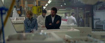 Movie still from “Burnt” (2015), directed by John Wells – A group of people standing around in a room; Medium shot, Over the shoulder angle