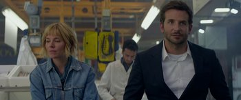 Movie still from “Burnt” (2015), directed by John Wells – A man and a woman sitting next to each other in a building; Close Up shot, Over the shoulder angle