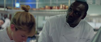 Movie still from “Burnt” (2015), directed by John Wells – A man in a chef's outfit in front of a counter; Close Up shot, Over the shoulder angle
