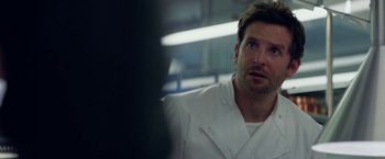 Movie still from “Burnt” (2015), directed by John Wells – A person wearing a lab coat; Close Up shot, Over the shoulder angle