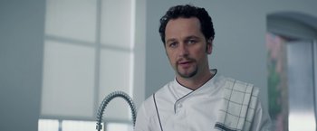 Movie still from “Burnt” (2015), directed by John Wells – A man in a chef's outfit is standing in front of a kitchen faucet; Close Up shot, Low angle