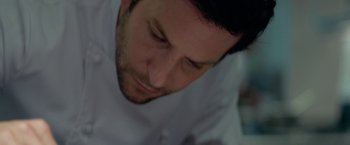Movie still from “Burnt” (2015), directed by John Wells – A man in a white shirt looking down; Extreme Close Up shot, High angle