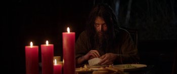 A man sitting at a dinner table with candles