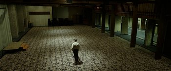 A man standing in the middle of an empty room at night
