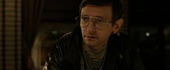 A person wearing glasses and a leather jacket