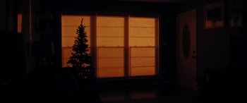Movie still from “By Night's End” (2020), directed by Walker Whited – A christmas tree in front of a large window; Extreme Wide shot, Low angle