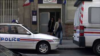 Movie still from “Caché” (2005), directed by Michael Haneke – A man and a woman walking down a street; Wide shot, Over the shoulder angle