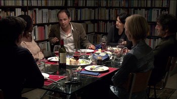 Movie still from “Caché” (2005), directed by Michael Haneke – A group of people sitting around a table with wine; Medium shot, Over the shoulder angle