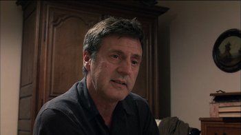 Movie still from “Caché” (2005), directed by Michael Haneke – A person sitting in a room; Close Up shot, Over the shoulder angle