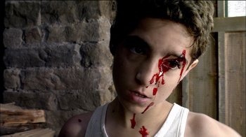 Movie still from “Caché” (2005), directed by Michael Haneke – A young man with blood on his face and a white t - shirt; Close Up shot, Overhead angle