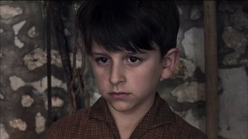Movie still from “Caché” (2005), directed by Michael Haneke – A young boy is looking at the camera; Close Up shot, High angle