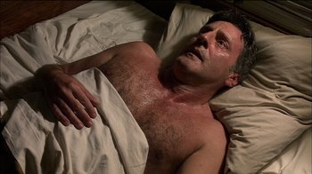 Movie still from “Caché” (2005), directed by Michael Haneke – A man laying in a bed with a blanket on top of him; Close Up shot, Overhead angle