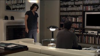 Movie still from “Caché” (2005), directed by Michael Haneke – Two people in a living room , one of whom is standing up; Wide shot, Over the shoulder angle