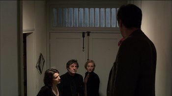 Movie still from “Caché” (2005), directed by Michael Haneke – A group of people standing in front of a door; Medium shot, Low angle