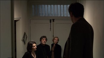 Movie still from “Caché” (2005), directed by Michael Haneke – A group of people standing in front of a door; Medium shot, Over the shoulder angle