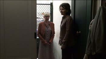 Movie still from “Caché” (2005), directed by Michael Haneke – Two women standing next to each other in front of a door; Medium shot, Over the shoulder angle