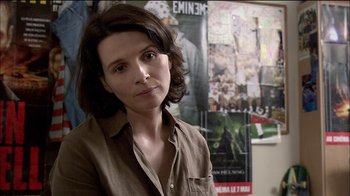 Movie still from “Caché” (2005), directed by Michael Haneke – A woman standing in front of a poster of a movie; Close Up shot, Over the shoulder angle