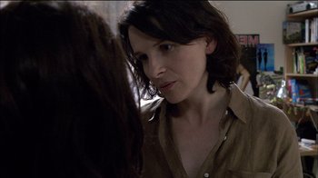 Movie still from “Caché” (2005), directed by Michael Haneke – A woman looking at the camera while standing next to another woman; Close Up shot, Over the shoulder angle