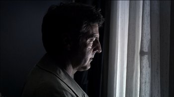 Movie still from “Caché” (2005), directed by Michael Haneke – A person looking out of a window; Close Up shot, Low angle