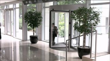 Movie still from “Caché” (2005), directed by Michael Haneke – A man is standing in a doorway of an office building; Wide shot, High angle