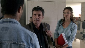 Movie still from “Caché” (2005), directed by Michael Haneke – A group of people standing in front of a mirror; Medium shot, Over the shoulder angle