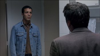 Movie still from “Caché” (2005), directed by Michael Haneke – A young man standing in front of an older man in front of a bathroom mirror; Medium shot, Over the shoulder angle