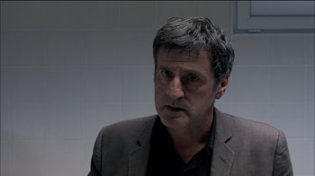 Movie still from “Caché” (2005), directed by Michael Haneke – A person wearing a suit and tie; Close Up shot, Over the shoulder angle