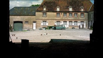 Movie still from “Caché” (2005), directed by Michael Haneke – A couple of birds standing on top of a dirt field; Extreme Wide shot, High angle