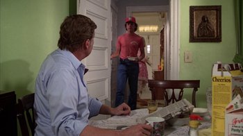 Movie still from “Caddyshack” (1980), directed by Harold Ramis – A man standing in front of another man holding a plate in his hand; Medium shot, Over the shoulder angle