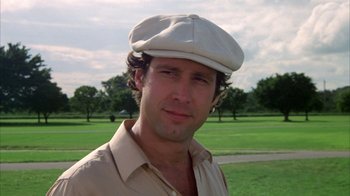 Movie still from “Caddyshack” (1980), directed by Harold Ramis – A person wearing a hat near a park; Close Up shot, Low angle