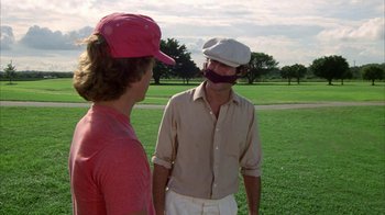 Movie still from “Caddyshack” (1980), directed by Harold Ramis – Two men in a field talking to each other; Close Up shot, Over the shoulder angle