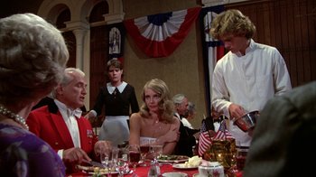 Movie still from “Caddyshack” (1980), directed by Harold Ramis – A group of people sitting at a table with food; Medium shot, Over the shoulder angle