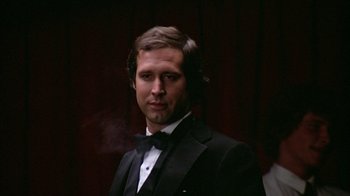 Movie still from “Caddyshack” (1980), directed by Harold Ramis – A man in a tuxedo is smoking a cigarette; Close Up shot, Low angle