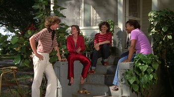 Movie still from “Caddyshack” (1980), directed by Harold Ramis – A group of people sitting on steps talking; Wide shot, Low angle