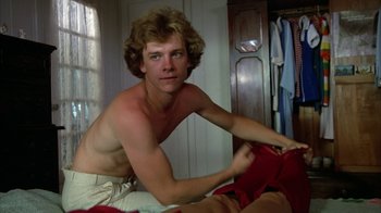 Movie still from “Caddyshack” (1980), directed by Harold Ramis – A shirtless man sitting on top of a bed in a bedroom; Medium shot, Over the shoulder angle