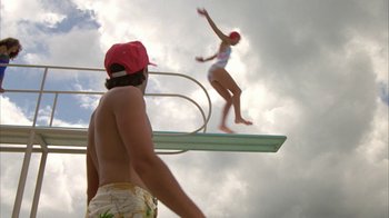 Movie still from “Caddyshack” (1980), directed by Harold Ramis – A man and a woman diving off of a diving board; Wide shot, Overhead angle