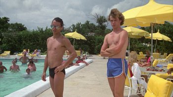 Movie still from “Caddyshack” (1980), directed by Harold Ramis – Two young men standing next to each other near a swimming pool; Medium shot, Low angle