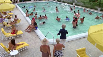 Movie still from “Caddyshack” (1980), directed by Harold Ramis – A group of people swimming in a swimming pool; Extreme Wide shot, High angle
