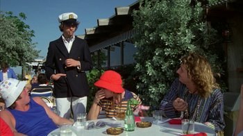 Movie still from “Caddyshack” (1980), directed by Harold Ramis – A group of people sitting around a table; Medium shot, Over the shoulder angle
