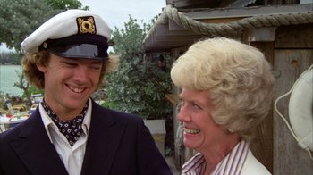 Movie still from “Caddyshack” (1980), directed by Harold Ramis – A man and a woman smiling for the camera; Close Up shot, Over the shoulder angle