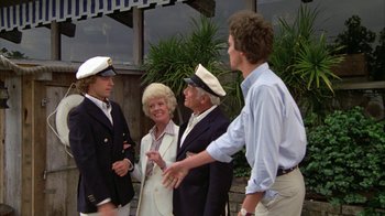 Movie still from “Caddyshack” (1980), directed by Harold Ramis – A group of people standing next to each other on a sidewalk; Wide shot, Low angle