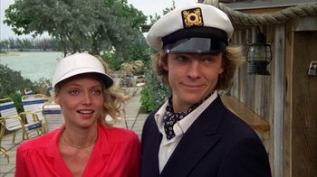 Movie still from “Caddyshack” (1980), directed by Harold Ramis – A man and a woman wearing hats posing for a picture; Close Up shot, Low angle