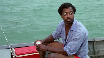 Movie still from “Caddyshack” (1980), directed by Harold Ramis – A man sitting on a boat with his eyes wide open; Close Up shot, Low angle