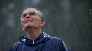 Movie still from “Caddyshack” (1980), directed by Harold Ramis – An older man wearing a raincoat in the rain; Close Up shot, Low angle