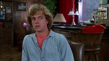 Movie still from “Caddyshack” (1980), directed by Harold Ramis – A young man sitting in front of a table; Close Up shot, Over the shoulder angle