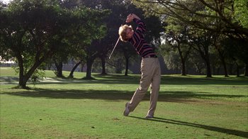 Movie still from “Caddyshack” (1980), directed by Harold Ramis – A man swinging a golf club on a golf course; Wide shot, Low angle