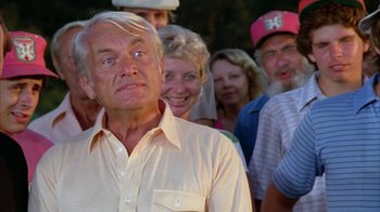 Movie still from “Caddyshack” (1980), directed by Harold Ramis – An older man standing in front of a group of older people; Close Up shot, Low angle