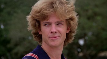 Movie still from “Caddyshack” (1980), directed by Harold Ramis – A young man with blonde hair and a blue shirt; Close Up shot, Low angle
