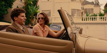 Movie still from “Café Society” (2016), directed by Woody Allen – A woman sitting in the driver's seat of an antique car; Wide shot, High angle